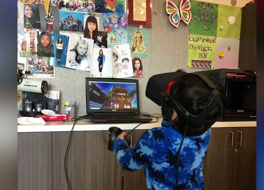 A young patient playing in virtual reality in their hospital room.